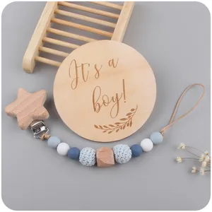 Detail of wooden milestone card for boys with handmade silicone pacifier clip set