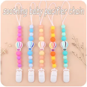 Detailed view of five colorful silicone pacifier clips with hot air balloon charms