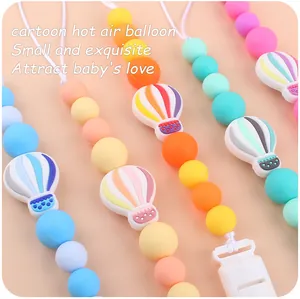 Detail of cartoon hot air balloon silicone pacifier clips in pastel macaron colors