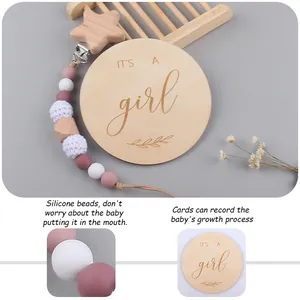 Wooden baby milestone set with a silicone pacifier clip and It's a girl engraved card