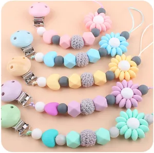 Detailed view of silicone and knit pacifier clips in five soft pastel macaron colors