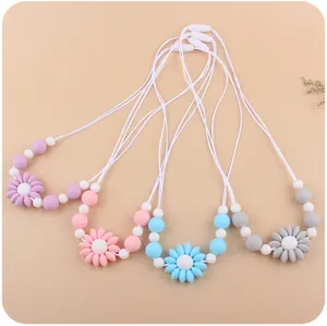 Close-up of baby silicone teething necklace with daisy flower charms and safety buckles