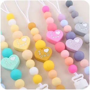 Dettaglio di catenelle portaciuccio in silicone con ciondoli a cuore I Love Mom e Dad