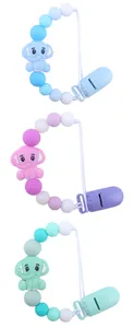 Detailed view of silicone baby pacifier clips in blue, pink, and green elephant designs