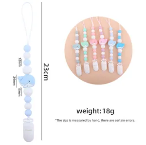 Detailed view of silicone pacifier clips featuring cartoon whales and macaron beads
