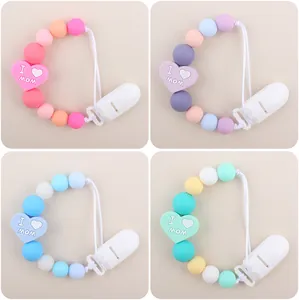 Dettaglio di quattro catenelle portaciuccio in silicone con perle a cuore I Love Mom