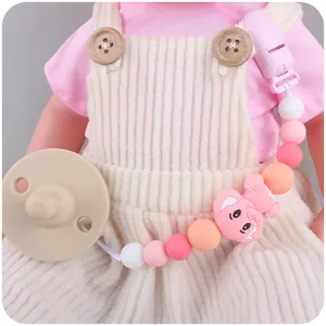 Silicone pacifier chain with pink cartoon elephant beads on a doll model outfit