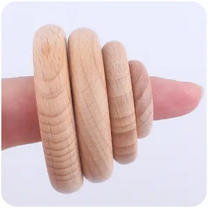 Primo piano di quattro anelli in legno di faggio naturale per massaggiagengive e DIY