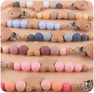 Dettaglio di catenelle per ciuccio colorate in silicone e faggio con stelle di legno