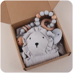 Baby lion gift set with grey bib, wooden pacifier chain, teether, and silicone dummy in box