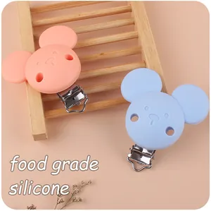Detail of food grade silicone bear pacifier clips in soft pink and blue colors