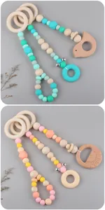 Detail of baby stroller pendant featuring natural beech wood beads and colorful silicone rings