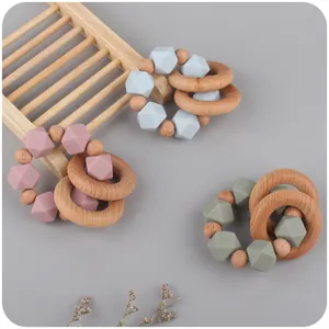 Tre anelli da dentizione in legno di faggio e silicone nei colori rosa, blu e oliva