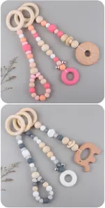 Detail of wooden beech animal teethers with colorful silicone beads and metal bells