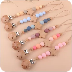 Dettaglio di catenelle portaciuccio con stelle in faggio e perline di silicone colorate