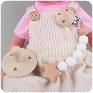 Beech wood pacifier clip set with silicone beads and star pendant on a baby model