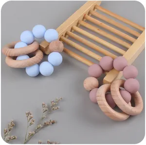 Detail of natural beech wood and food-grade silicone baby teething rings with beads