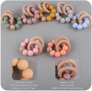 Macro shot of 7 colorful silicone beads and natural beech wood rings for baby teething toy