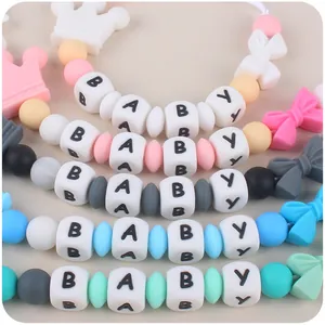 Macro shot of colorful food-grade silicone teething beads with BABY letters and crown shapes
