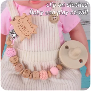 Détail d'attache lion en bois, perles lettres baby et sucette en silicone rose