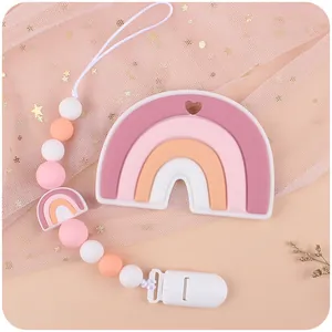 Close-up of silicone baby pacifier clip with rainbow teether and morandi beads on pink lace