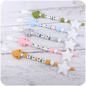 Silicone baby pacifier clips with colorful beads and leaf star charms on wood