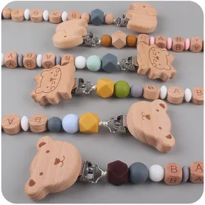 Detalle de sujetachupetes de madera con cuentas de silicona y clips de animales