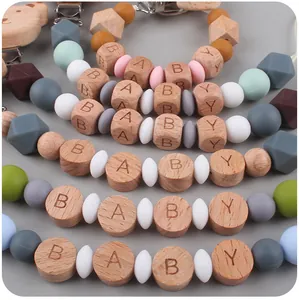 Detalle de sujetachupetes de madera de haya con cuentas de silicona y grabado de BABY