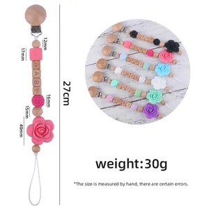 Attache-tétine en bois de hêtre et silicone avec perles de rose et texte baby pour bébé