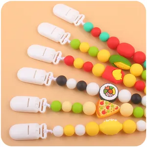 Close-up of colorful silicone pacifier clips with various cartoon food-shaped beads