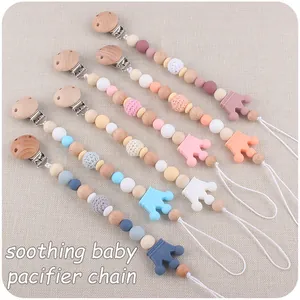 Detail of five baby pacifier clips featuring crown silicone beads and beech wood clips