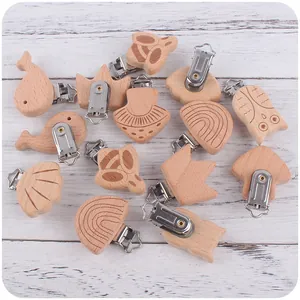 Macro-detail van diverse beukenhouten speenclips in dierenvormen met metalen gespen