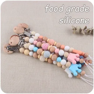 Detail of baby pacifier clip with beech wood, silicone beads and crown pendant