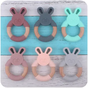 Close-up of silicone bunny teether rings with natural beech wood in six pastel colors