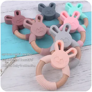 Detail of colorful silicone rabbit teethers with natural beech wood rings for infants