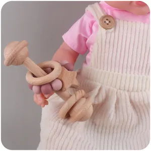 Detailansicht von Baby-Holzrassel und Silikon-Beißring-Set, gehalten von einem Kind