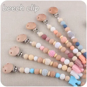 Detail of beech wood pacifier clips with silicone beads and crown shaped charm
