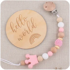 Close-up of beech wood pacifier clip with pink silicone crown and beaded chain