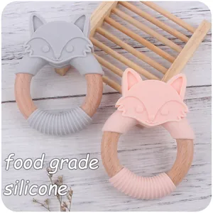 Détail des anneaux de dentition en silicone renard rose et gris avec cercle en bois naturel