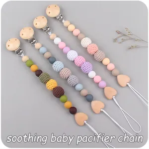 Detailed view of handmade pacifier clips with wood, silicone beads and crochet textures