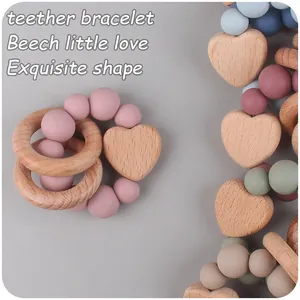 Dettaglio macro del cuore in legno di faggio e perline di silicone sul braccialetto