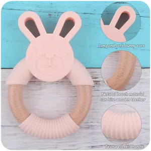Detail of pink silicone bunny ears and natural beech wood ring for baby teething relief