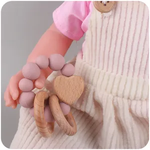 Dettaglio del massaggiagengive con perline in silicone rosa e ciondolo a cuore in faggio