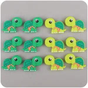 Vista detallada de doce cuentas de tortuga de silicona verde para manualidades infantiles DIY