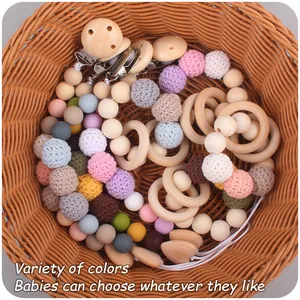 Close-up of baby pacifier clips and wooden teethers in various colors in a basket