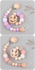 Macro detail of wooden pacifier clips with crochet beads and heart pendant for babies