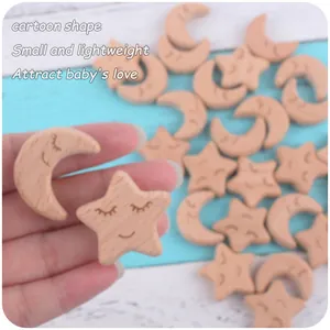 Close-up of wooden star and moon teething beads with smiling faces for DIY pacifier clips