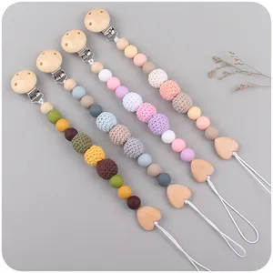 Set of four handmade crochet and wooden baby pacifier clips in neutral earth tones