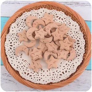 Macro detail of natural beech wood star and moon beads with engraved smiley faces for DIY crafts