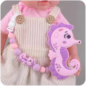 Detail eines rosa Silikon-Seepferdchen-Beißrings mit Perlenkette und Schnullerclip